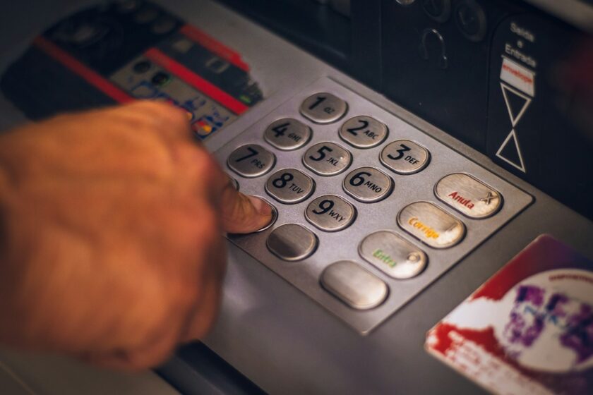 Persona con carta bancaria rossa e bianca in mano