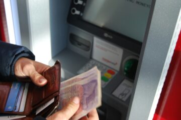 Persona che tiene un portafoglio con banconote in mano