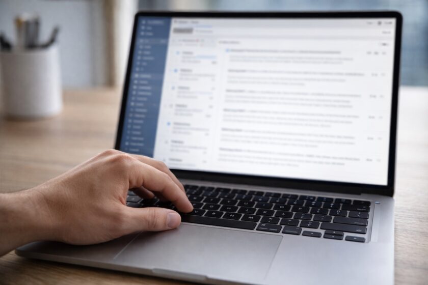 Persona che scrive una email di outreach su laptop in un contesto professionale