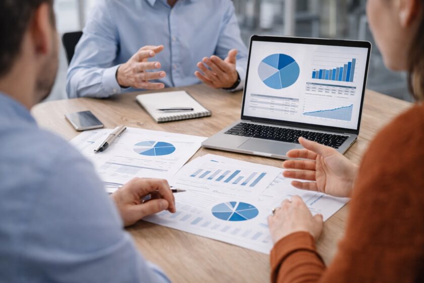 Team in riunione che analizza grafici e budget per decidere investimenti tra prodotti e business unit